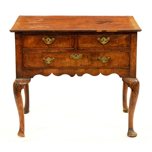 1326 - A George II walnut lowboy, with oversailing quarter veneered top and fitted three drawers to the sha... 