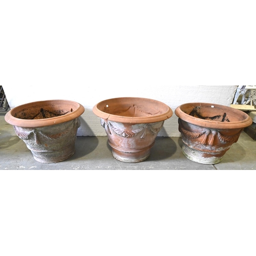 1362 - Three matching terracotta festoon and tassel terrace pots, 20th c,  46cm h, 68cm diam and smaller... 