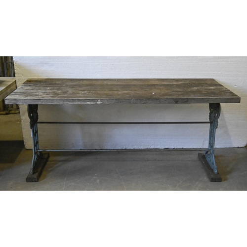 1381 - A garden table,  the substantial weathered three plank top on ornate Victorian cast iron trestles un... 