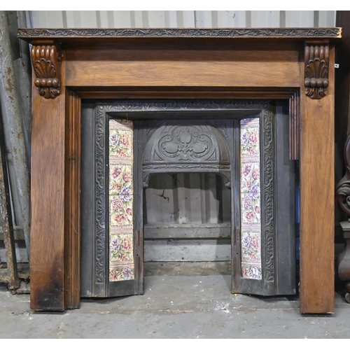 1387 - A carved and stained wood chimneypiece and a Victorian tiled cast iron hooded fire surround,  chimne... 