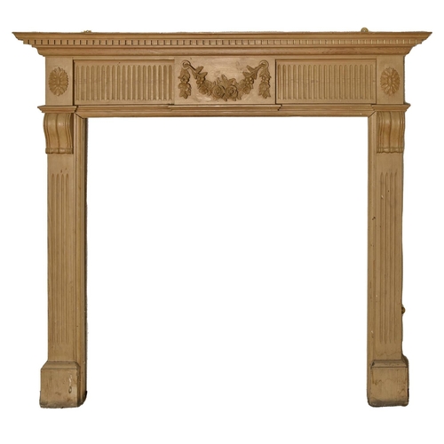 1400 - A neo classical style pine chimneypiece, with festoon tablet flanked by paterae,   131 cm h, 143cm l... 