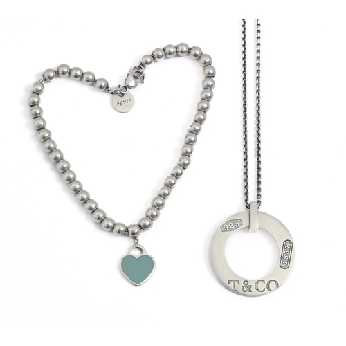 277 - Tiffany & Co. A silver beads bracelet with enamel heart charm and a silver ring pendant on neckl... 