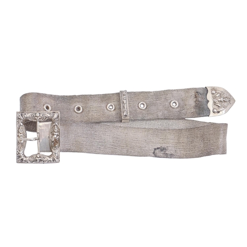 317 - A South East Asian silver repousse belt buckle and silver mesh waist belt, early 20th c, 66cm l, 4oz... 