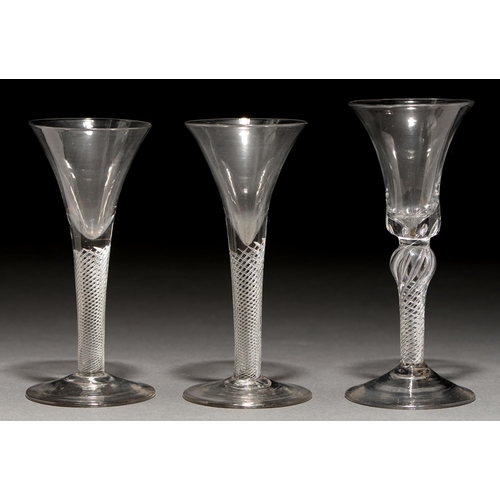 728 - Three wine glasses, mid 18th c,  with trumpet or bell bowl, on single series air twist stem and coni... 