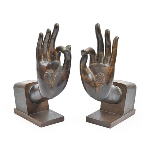 934 - A pair of South East Asian bronze sculptures of the hands of Buddha,  mounted on stained wood, 23cm ... 