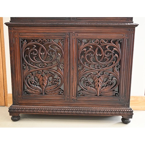 1355 - An Anglo-Indian carved and panelled padouk cabinet, 19th c, enclosed by fretwork and glazed doors, o... 