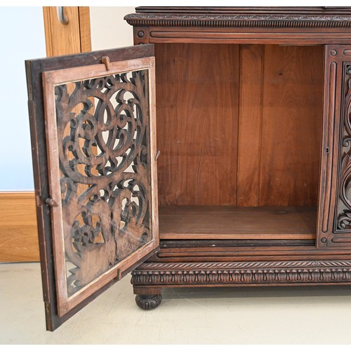 1355 - An Anglo-Indian carved and panelled padouk cabinet, 19th c, enclosed by fretwork and glazed doors, o... 