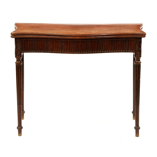 1181 - A George III serpentine mahogany tea table, with nulled frieze, on stop fluted tapering turned legs ... 