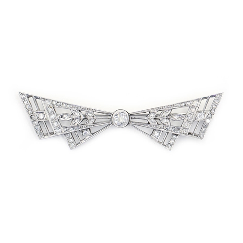 120 - A diamond bow brooch, with larger central diamond collet, in white gold, 57mm, 6.7g