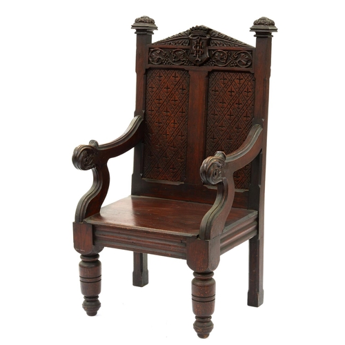 1216 - A Victorian carved and stained oak panel back armchair, with crown and sacred monogram borne on a sh... 