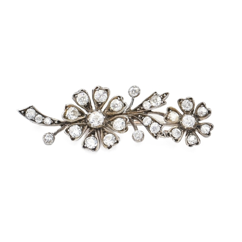 122 - A diamond spray brooch, c1900, of two flowers mounted in silver and gold, 44mm l, 6g... 