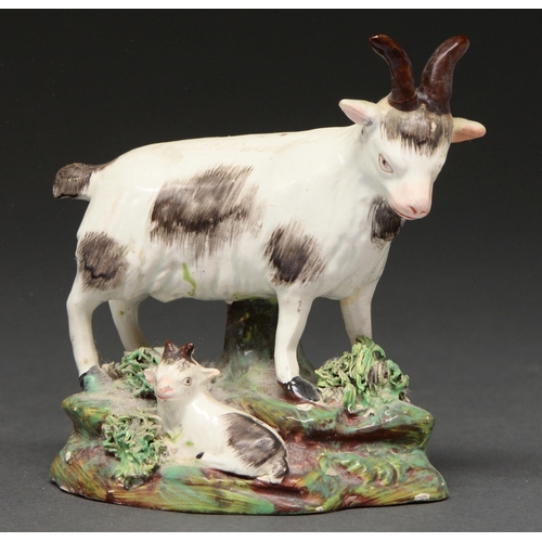 640 - A Staffordshire earthenware group of a goat and kid, c1830, one tufted, rocky mound, 10cm h... 