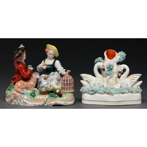 650 - A German porcelain group of a seated youth and girl with animals and a birdcage, late 20th c, 13cm h... 