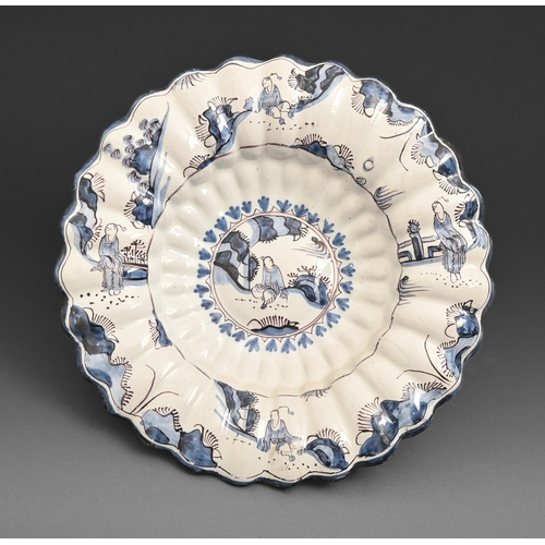 719 - A German faience moulded dish, buckelplatte, probably Hanau, first half 18th c, painted in blue and ... 