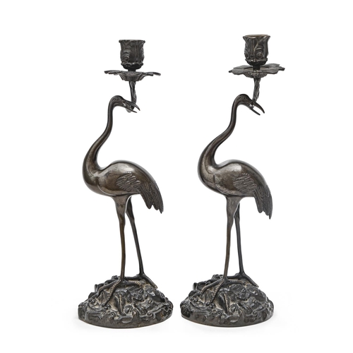 819 - A pair of French bronze naturalistic stork candlesticks, late 19th c, the bird standing on a rocky m... 