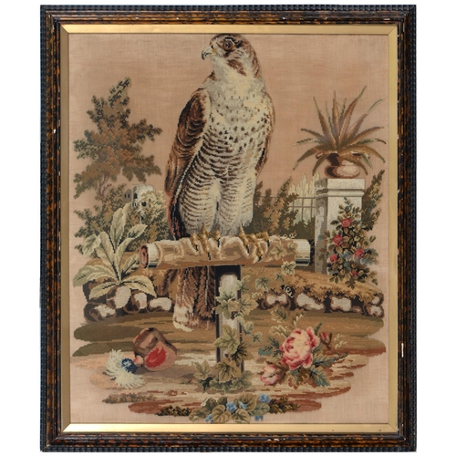 928 - A Victorian Berlin woolwork picture of  falcon on a perch in a garden with glass eye, 67 x 55cm... 