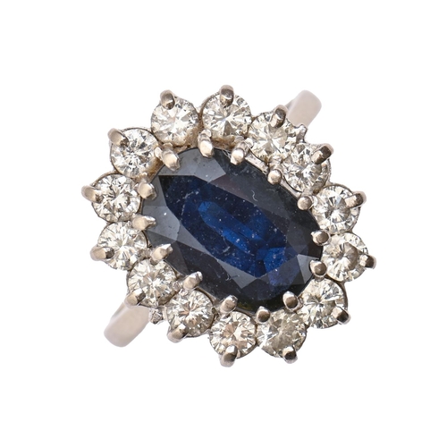 19 - A sapphire and diamond ring, with 9 x 12mm oval sapphire in diamond surround, in 18ct white gold, 7.... 