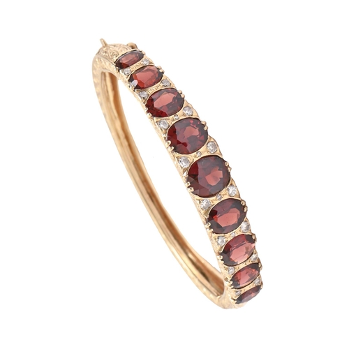 63 - A garnet and diamond bangle, in 14ct gold, 55mm (internal), marks obscured, 31.2g