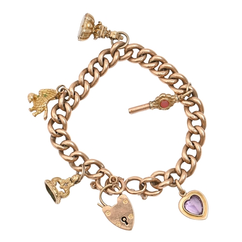 69 - A gold curb bracelet and padlock, mounted with earlier gold and base metal charms, fob seals and a w... 