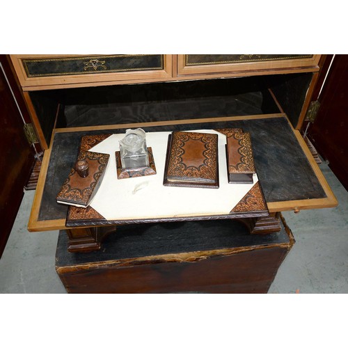 1212 - A Spanish tooled leather writing cabinet, c1920, with breakarched pediment and fitted interior with ... 