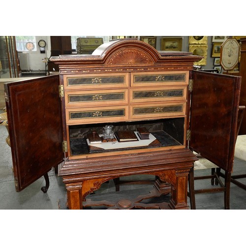 1212 - A Spanish tooled leather writing cabinet, c1920, with breakarched pediment and fitted interior with ... 