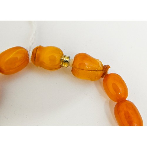 159 - A necklace of amber beads, 52g