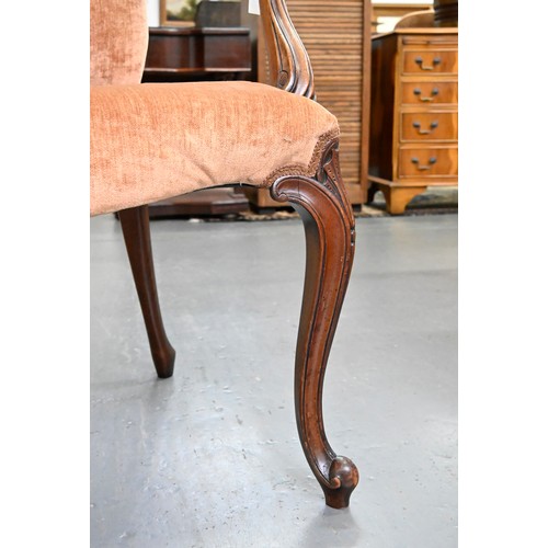 1304 - A pair of mahogany armchairs, in George III style, on shell carved cabriole legs, the padded arms te... 