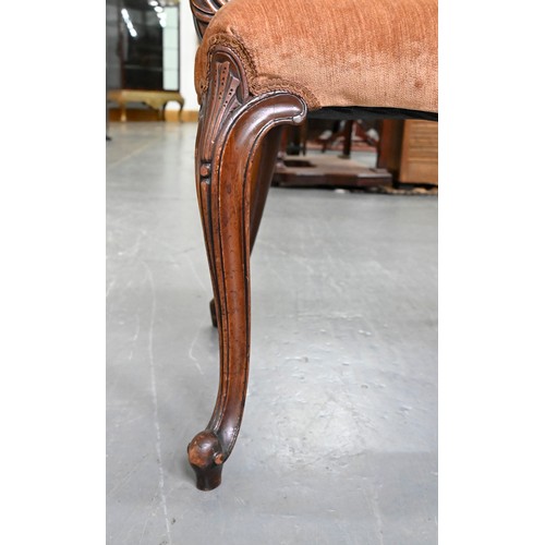 1304 - A pair of mahogany armchairs, in George III style, on shell carved cabriole legs, the padded arms te... 