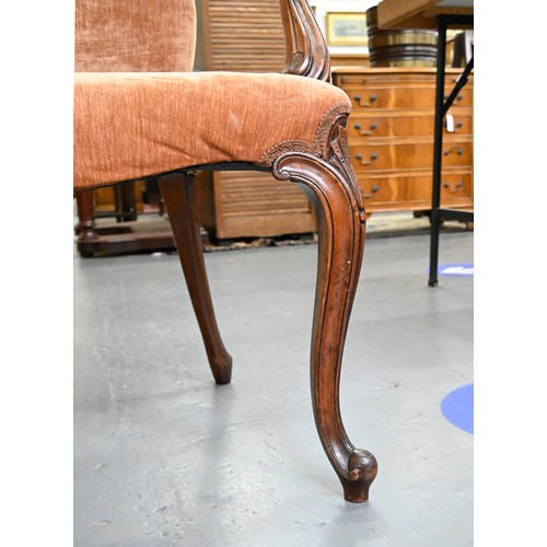 1304 - A pair of mahogany armchairs, in George III style, on shell carved cabriole legs, the padded arms te... 