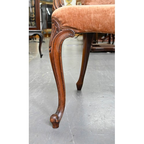 1304 - A pair of mahogany armchairs, in George III style, on shell carved cabriole legs, the padded arms te... 