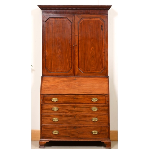 1025 - A George III mahogany bureau and associated bookcase, the dentil cornice above adjustable shelves en... 