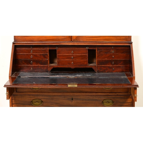 1025 - A George III mahogany bureau and associated bookcase, the dentil cornice above adjustable shelves en... 