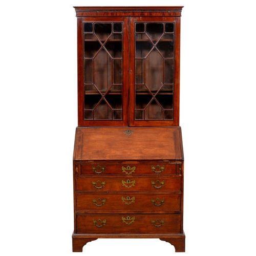 1031 - A George III mahogany bureau, the associated bookcase with dentil cornice above adjustable shelves e... 