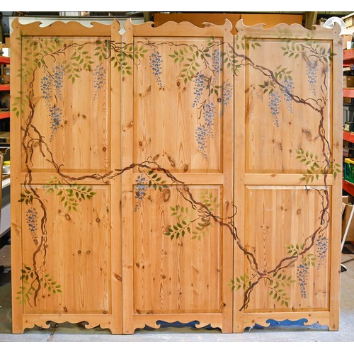 1035 - A stencilled and waxed pine screen, of three twin panelled leaves decorated with wisteria, 189 x 201... 