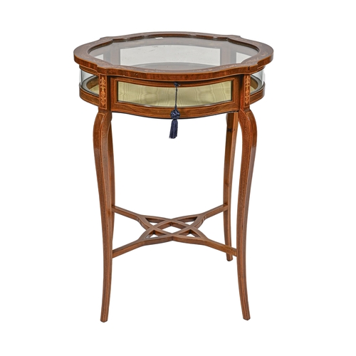 1009 - An Edwardian mahogany and inlaid display table, the shaped circular top with glazed sides on slender... 