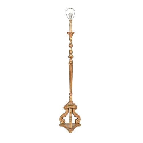 1016 - A giltwood standard lamp, mid 20th c, on three scroll brackets and incurved base, 141cm h excluding ... 