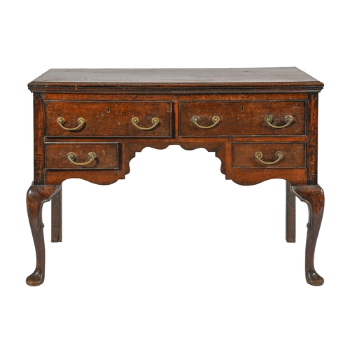 1023 - An oak lowboy, 19th c, fitted with four drawers about the shaped apron, on cabriole forelegs, 84cm h... 