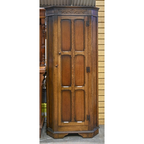 1036 - An antique style panelled oak wardrobe, with carved frieze, 178cm h; 81 x 43cm