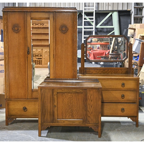 1039 - A 1930s oak three piece bedroom suite, the wardrobe with mirrored central door, 192cm h, mirror back... 