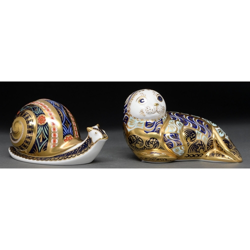 562 - Two Royal Crown Derby harbour seal and garden snail paperweights, printed mark, gilt stopper, certif... 