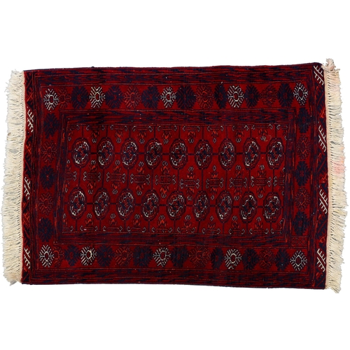 969A - A Red Afghan Bokhara rug, 115cm x 82cm