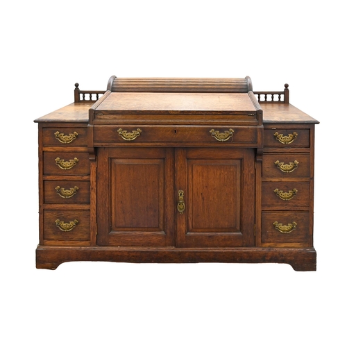 980 - An Edwardian oak desk, with four raised and fielded panels to the back, the galleried top surmounted... 