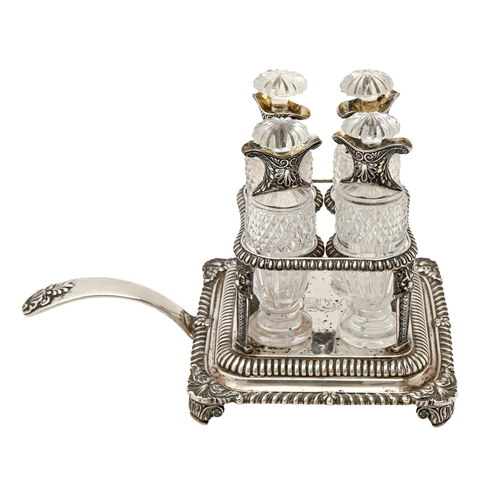 315 - A George IV gadrooned silver cruet frame, the curved handle with shell terminal, crested, the four v... 