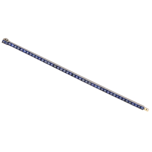 77 - A sapphire bracelet, c1930, as a single line of evenly sized calibre cut sapphires, mounted in plati... 