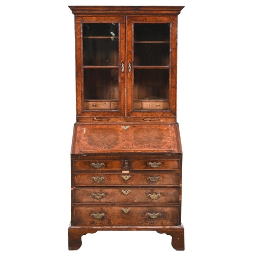 992 - A walnut bureau-cabinet, with ogee moulded cornice and glazed doors above candle slides, the flap in... 