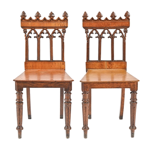 1025 - A pair of Victorian gothic oak hall chairs, the back with crocketed arches, 84cm h