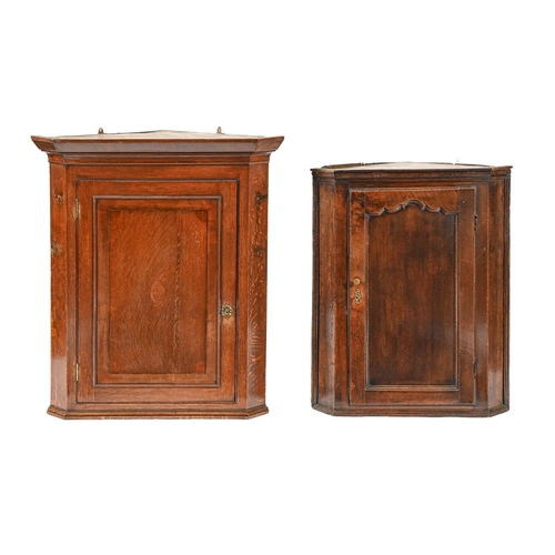 1039 - Two George III oak hanging corner cupboards, with panelled door, the larger 97cm h; 50 x 83cm... 