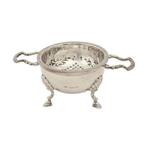 259 - A George V silver tea strainer and stand, 13cm over handles, by Fattorini & Sons Ltd, Birmingham... 