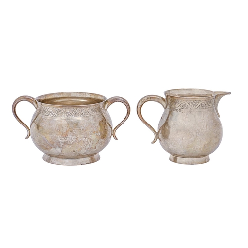 311 - A George V silver cream jug and sugar bowl, of bulbous form with foliate engraved border, jug 80mm h... 