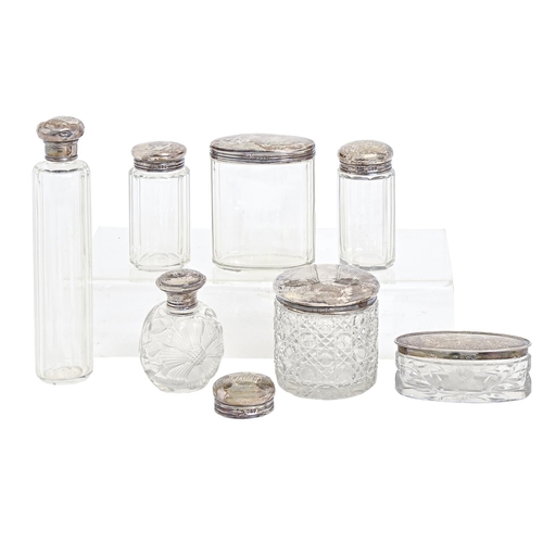 339 - Seven Edwardian and George V silver capped cut or faceted glass bottles and jars and another silver ... 